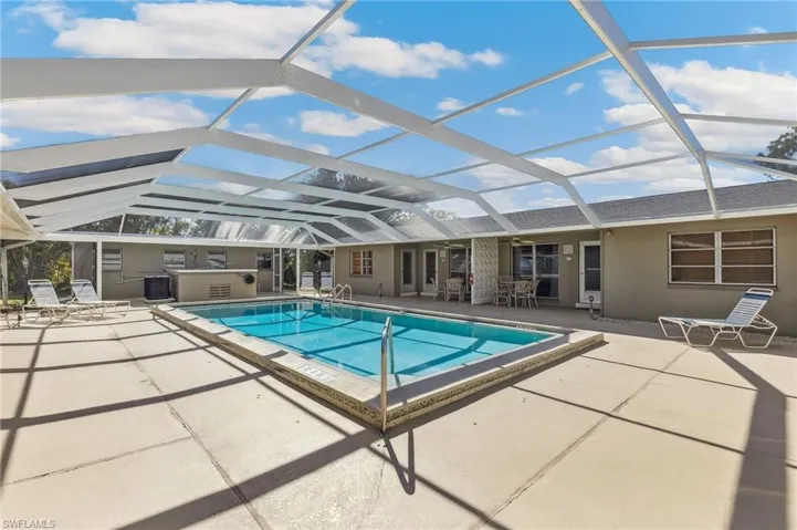 Community pool featuring new screen enclosure, unit patios, and ceiling fans