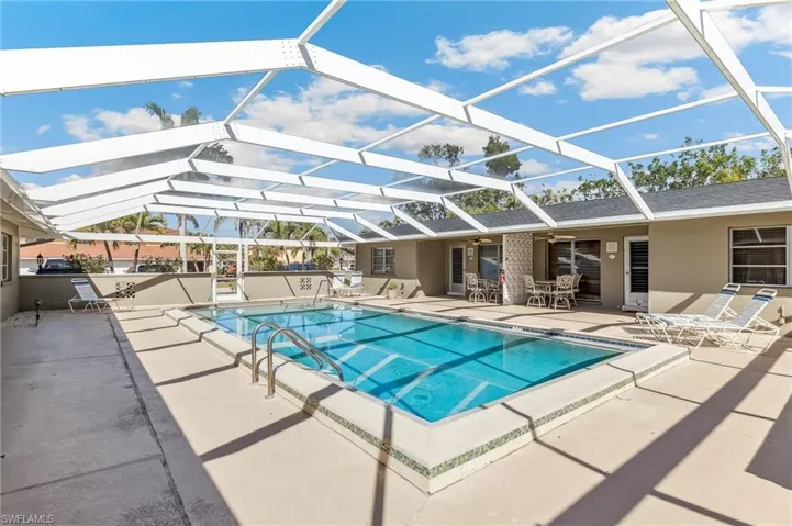 Community pool featuring new screen enclosure, unit patios, and ceiling fans