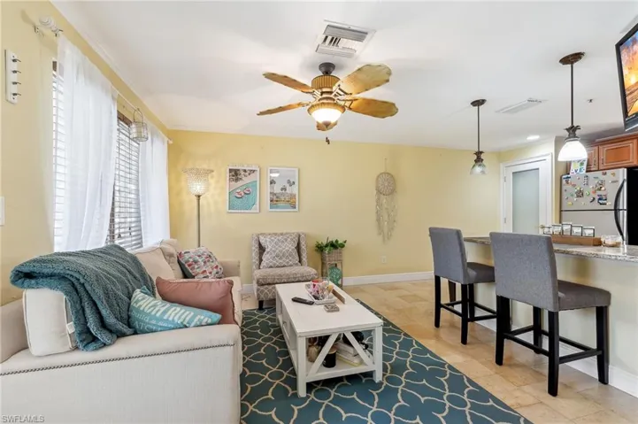 The Boca unit living area featuring baseboards, tile floors, and ceiling fan