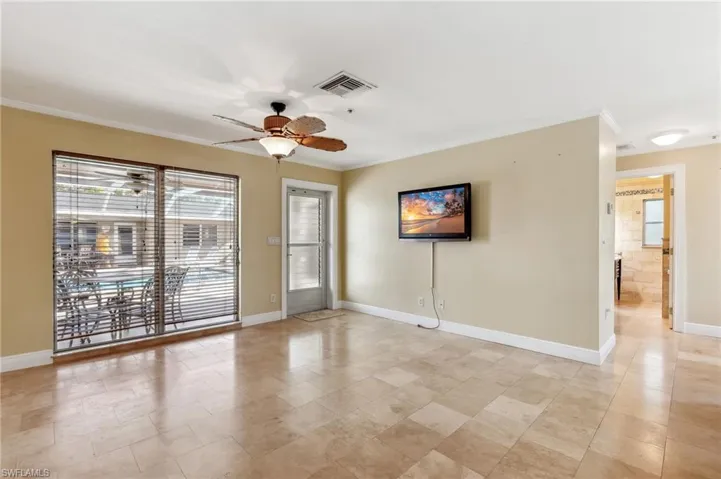 The Captiva unit living room with a ceiling fan, tile floors, crown molding, and baseboards