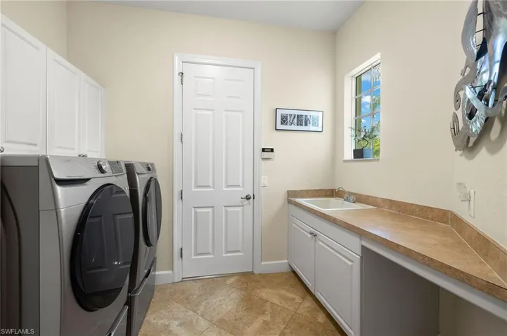 In-Residence Laundry Room with Pedestal Drawers under the Washer/Dryer allowing for easy access and door to garage