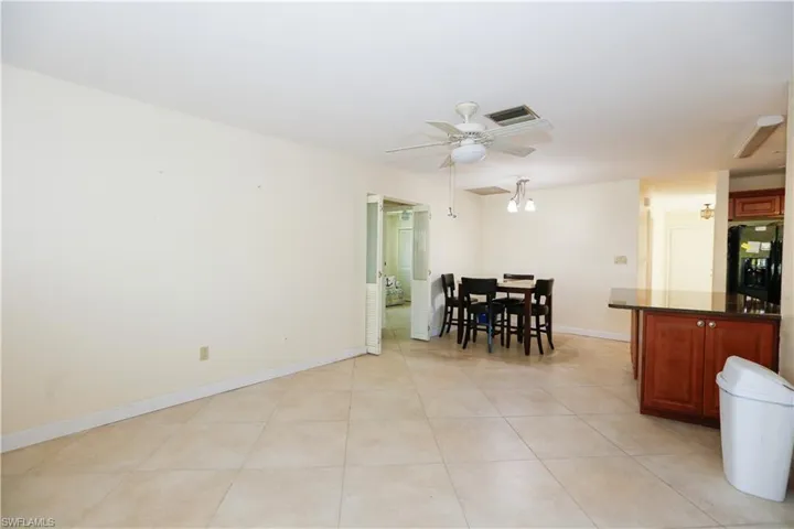 Kitchen featuring baseboards, light tile patterned flooring, dark countertops, visible vents, and ceiling fan