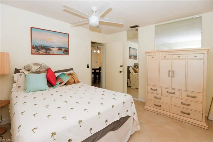 Bedroom with light tile patterned floors, visible vents, and ceiling fan