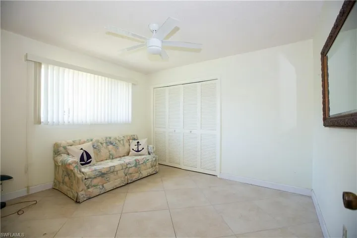 Unfurnished living room with tile patterned flooring, baseboards, and ceiling fan
