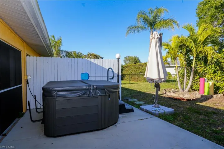 View of patio with a hot tub and a fenced backyard
