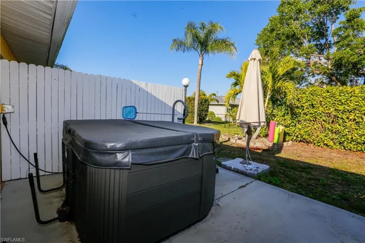 View of patio / terrace with fence and a hot tub