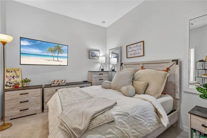 Bedroom featuring light gray wall paint, a tray ceiling, and tile flooring