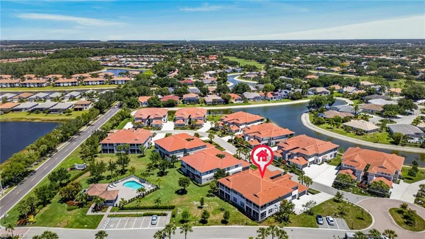 Aerial capturing a residential community featuring multiple buildings with red tile roofs