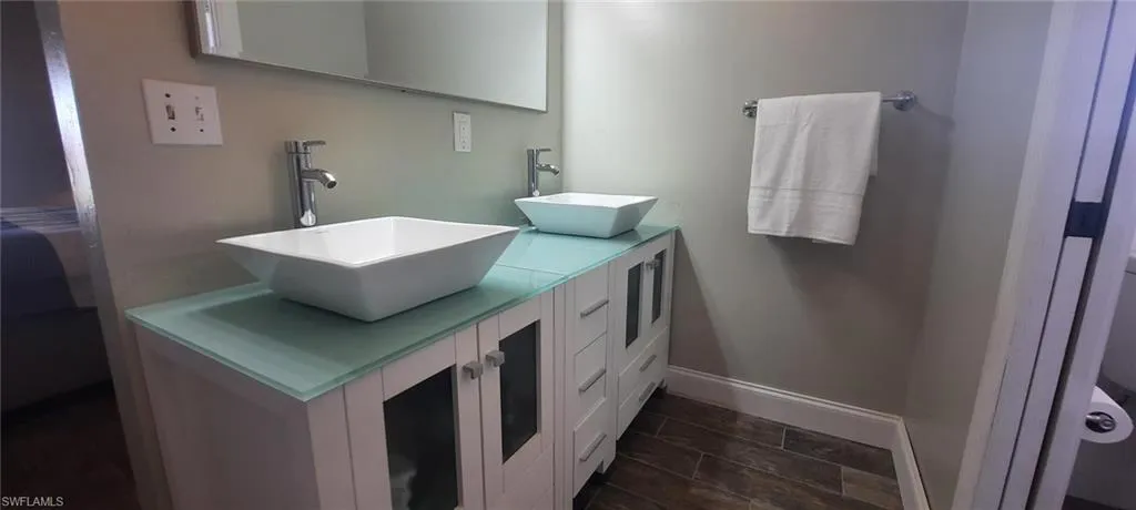 Bathroom with a sink, baseboards, and double vanity