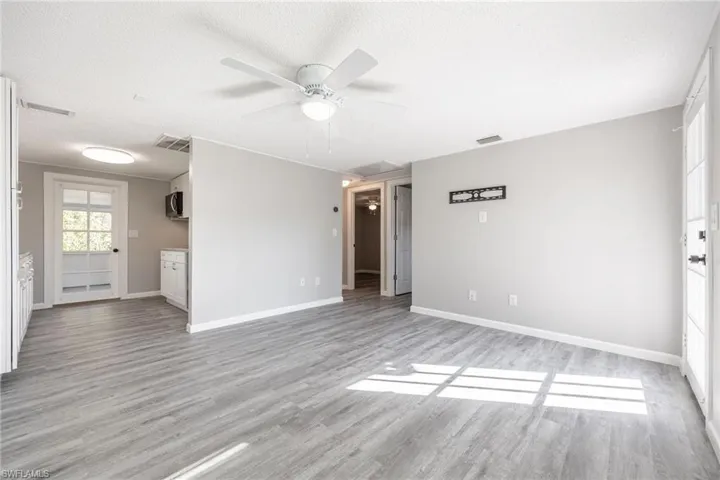 Unfurnished living room with ceiling fan, a textured ceiling, and light hardwood / wood-style floors