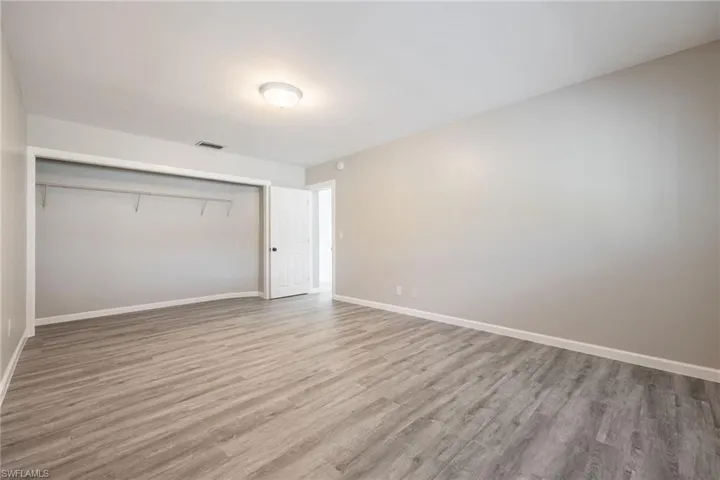 Unfurnished bedroom with light hardwood / wood-style flooring and a closet