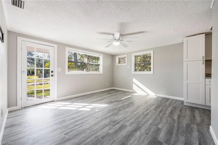 Unfurnished room with hardwood / wood-style floors, a textured ceiling, and ceiling fan
