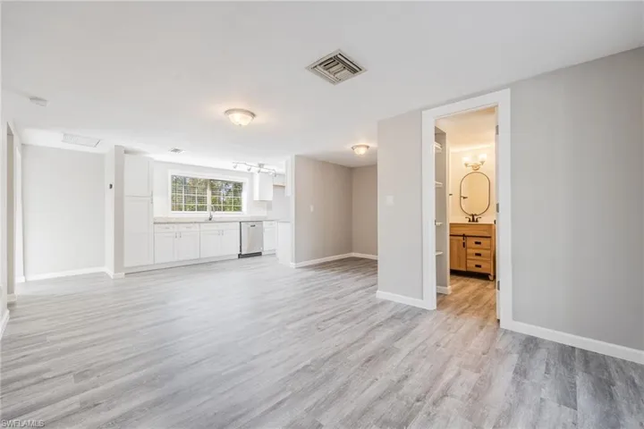 Unfurnished living room featuring sink and light hardwood / wood-style flooring