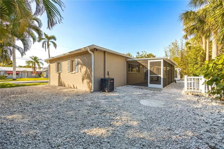 Rear view of property featuring a sunroom and central air condition unit