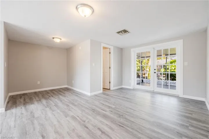 Unfurnished room with french doors and light hardwood / wood-style floors