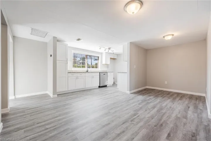 Unfurnished living room with sink and light wood-type flooring