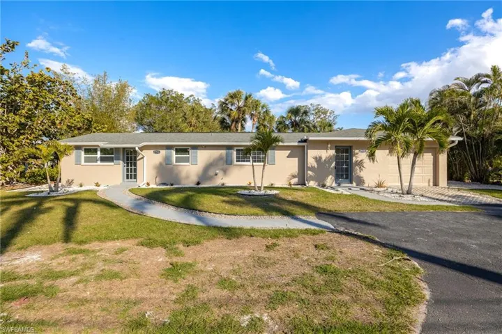 Single story home featuring a garage and a front lawn