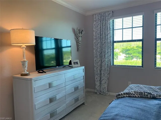 Master bedroom featuring ornamental molding and light carpet
