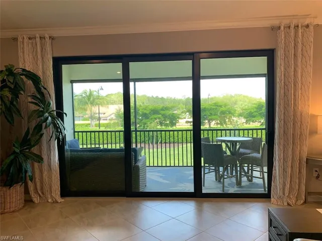Doorway to outside with light tile patterned flooring and crown molding