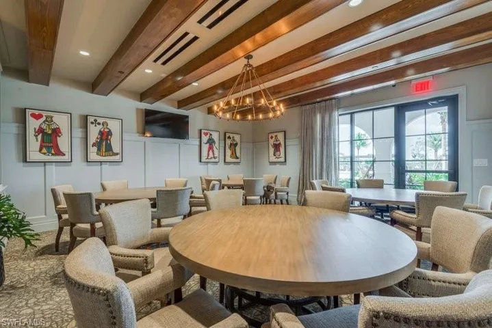 Community area with beamed ceiling and a chandelier