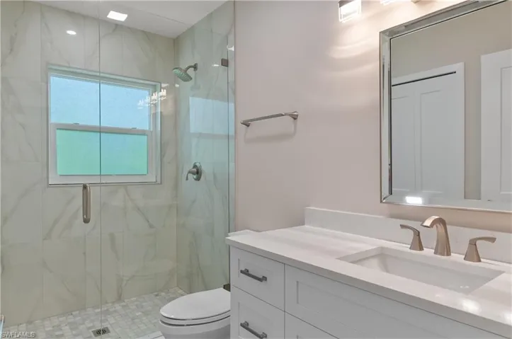 Full bath #1 featuring vanity and a marble finish shower