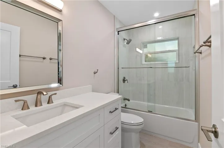 Bathroom #2 featuring combined bath / shower with glass door, vanity, and closet for  linens