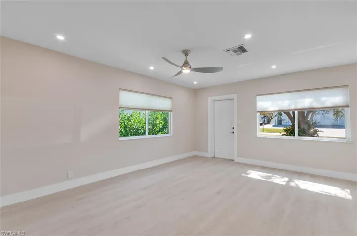 open floor plan dining and living room  light wood-style floors, ceiling fan, and recessed lighting