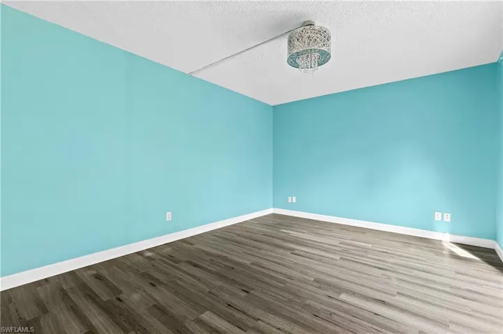 Unfurnished room featuring a textured ceiling and wood finished floors