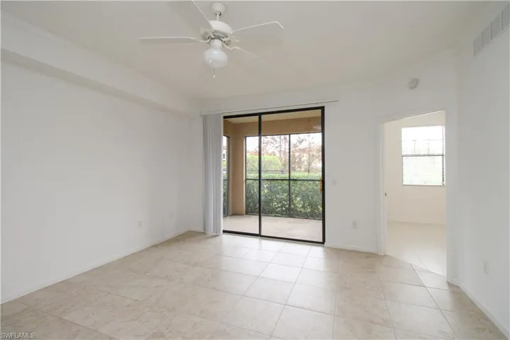 Tiled empty room featuring ceiling fan, crown molding, and a healthy amount of sunlight