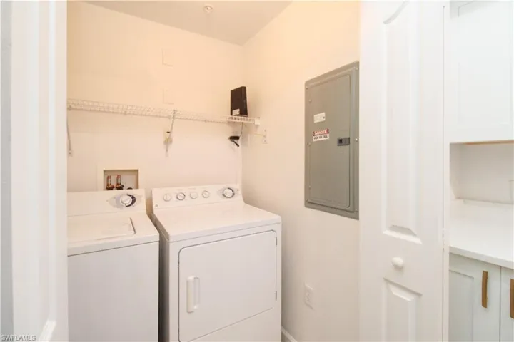 Laundry area with electric panel and washer and clothes dryer