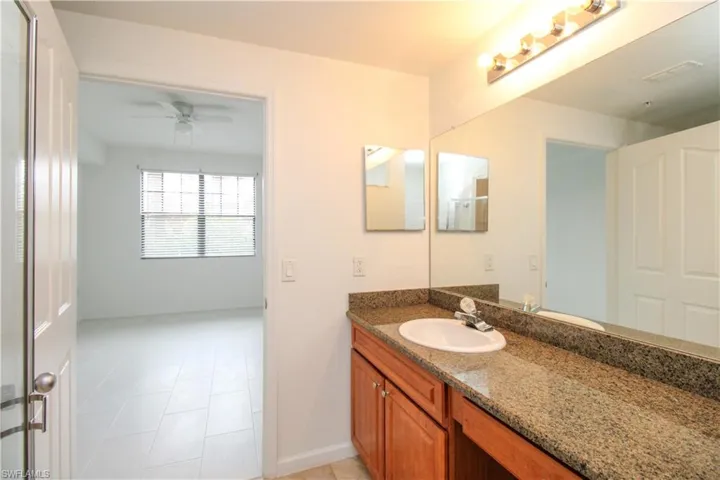 Bathroom with tile patterned flooring, vanity, and ceiling fan