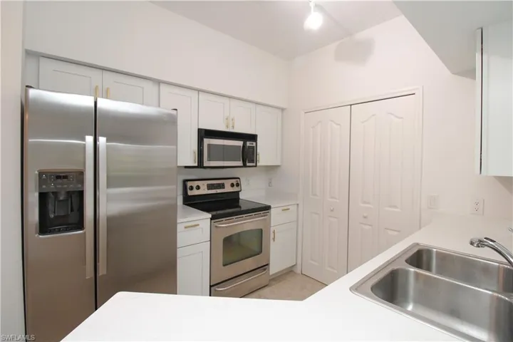 Kitchen with sink, white cabinets, and appliances with stainless steel finishes