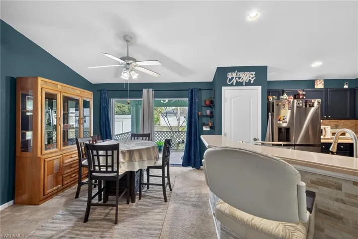 Dining area featuring light carpet, ceiling fan, vaulted ceiling, and recessed lighting