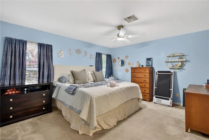 Carpeted bedroom with a ceiling fan