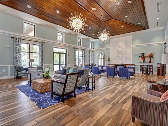 Spacious common area featuring wood-finish flooring, a vaulted wood-paneled ceiling, and multiple large windows