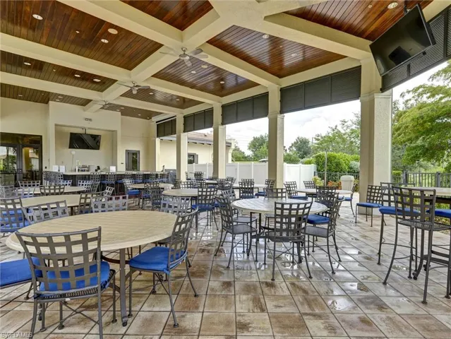 Expansive covered patio featuring a wood-finish coffered ceiling with recessed lighting and ceiling fans