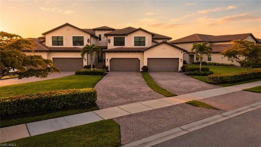 Stucco exterior featuring multiple garage bays, decorative window shutters, and a tile roof