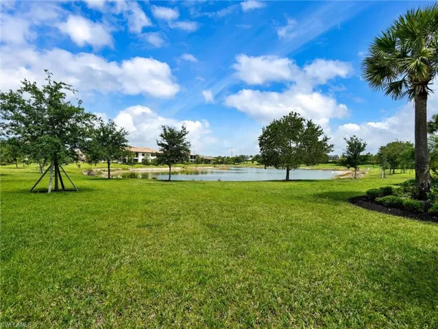 Expansive green lawn with a tranquil pond, surrounded by mature trees and lush landscaping