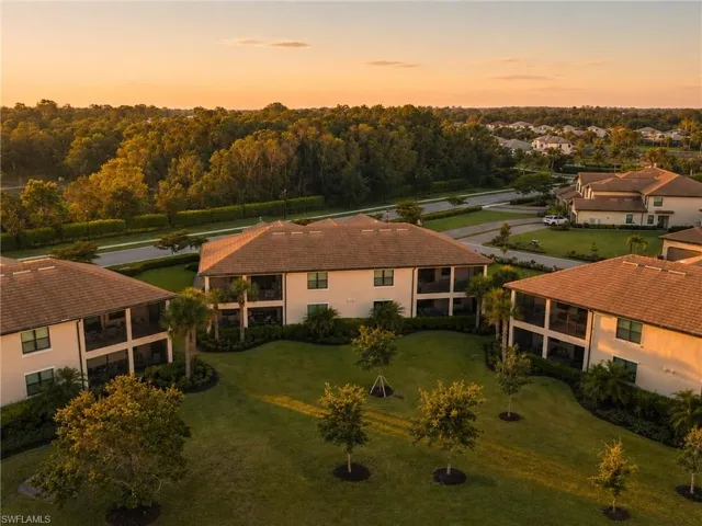Aerial perspective of a multi-unit residential property featuring stucco exteriors and tile roofs