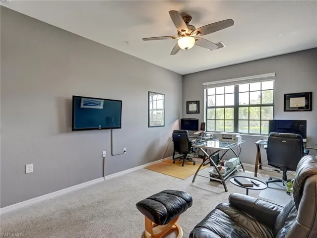 Carpeted room with a ceiling fan, dual windows, and light gray wall paint