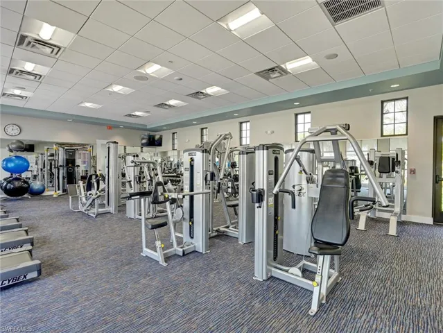 Fitness center featuring a variety of strength training equipment, padded blue and grey carpet, and recessed lighting