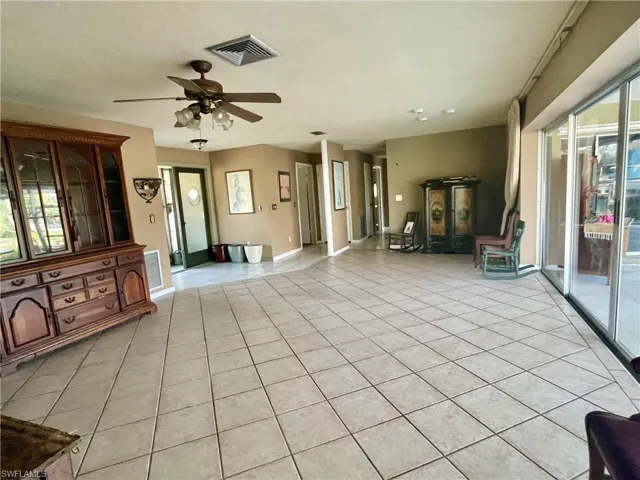 Unfurnished living room with ceiling fan and light tile patterned floors