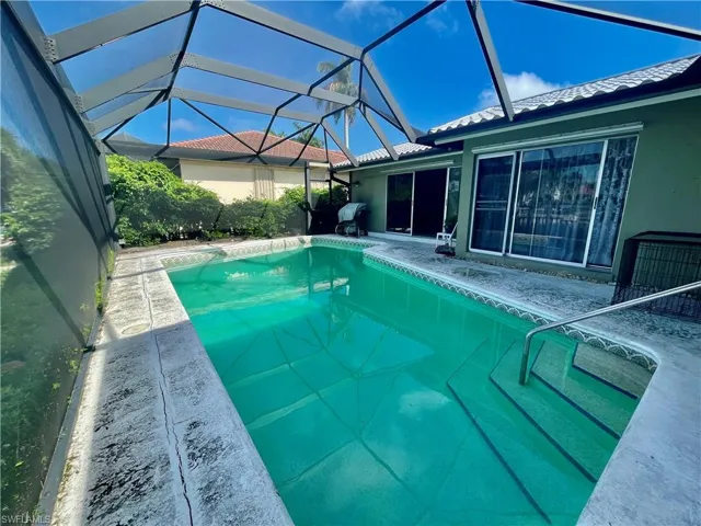 View of pool with a lanai and a patio