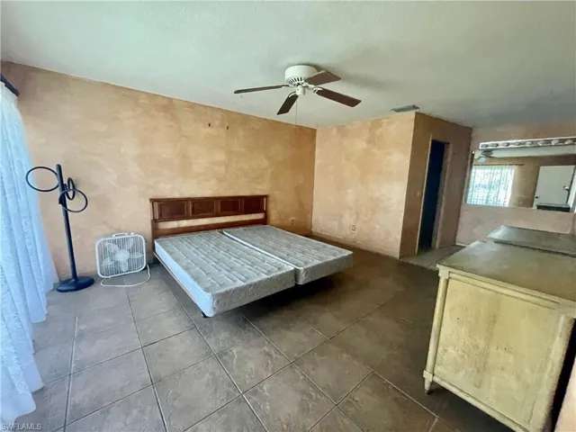 Unfurnished bedroom with ceiling fan and tile patterned floors