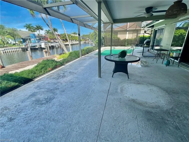 View of patio / terrace with glass enclosure, ceiling fan, and a water view