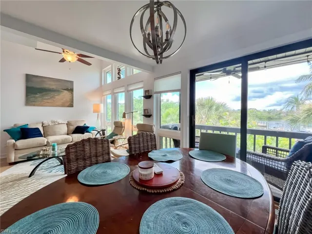 Dining area with ceiling fan with notable chandelier