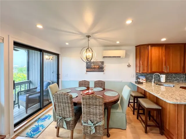 Dining space featuring a wall unit AC, sink, and an inviting chandelier