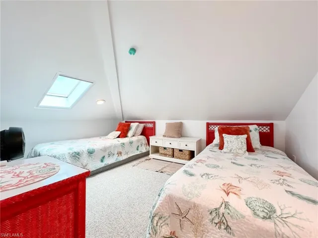 Bedroom featuring carpet and lofted ceiling with skylight