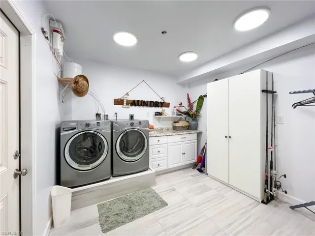 Laundry area featuring washer and clothes dryer, hookup for an electric dryer, and light tile floors