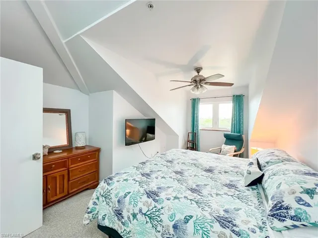 Carpeted bedroom featuring ceiling fan